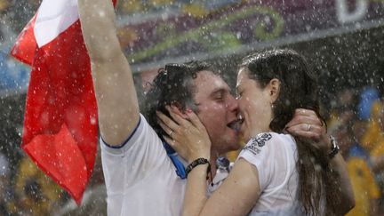 Des supporters fran&ccedil;ais s'embrassent pendant l'interruption du match Ukraine-France due &agrave; un gros orage, le 15 juin 2012 &agrave; Donetsk (Ukraine).&nbsp; ( MICHAEL BUHOLZER / REUTERS)