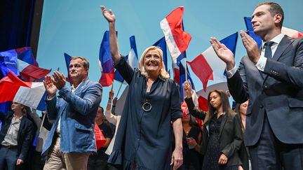 Marine Le Pen sur la scène du Palais des congrès du Cap d'Agde lors du meeting de clôture des journées parlementaire&nbsp;du Rassemblement national, dimanche 18 septembre 2022. (PASCAL GUYOT / AFP)