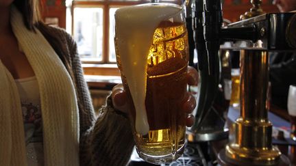 Une barmaid sert une pinte de bi&egrave;re dans un pub de l'est londonien, le 2 f&eacute;vrier 2012.&nbsp; (EDDIE KEOGH / REUTERS)