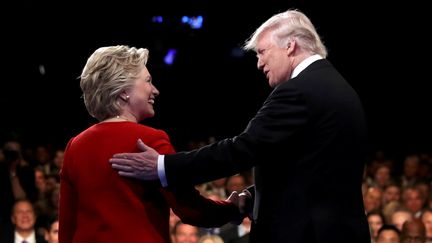 Donald Trump et hillary Clinton se serrent la main avant de s'affronter lors du premier débat de la présidentielle américaine, le 26 septembre 2016, à Hempstead.&nbsp; (JOE RAEDLE / REUTERS)