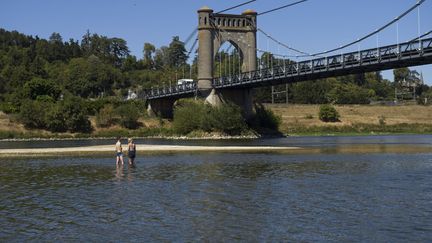 Un couple en maillot traverse la Loire à proximité du pont de Langeais le 8 août 2022. Photo d'illustration. (GUILLAUME SOUVANT / AFP)