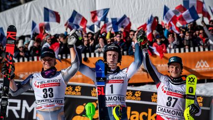 Clément Noël (au centre), entouré de Timon Haugan et Adrian Pertl fête sa victoire à Chamonix le 8 février 2020. Un an plus tard, il n'y aura pas de public pour le slalom. (JEFF PACHOUD / AFP)