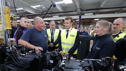 Emmanuel Macron avec des employés de Whirpool, lors de sa visite dans l'usine à Amiens, le 3 octobre 2017. (PHILIPPE WOJAZER / POOL)