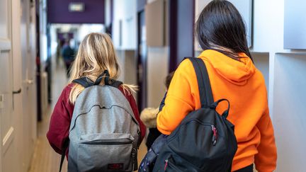 Des élèves de 3e marchent dans un couloir d'un collège de Paris, le 14 janvier 2022. (ALINE MORCILLO / HANS LUCAS / AFP)