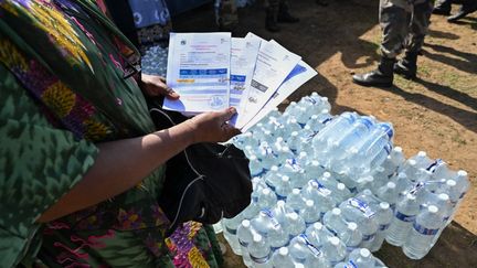 Une habitante attend de récupérer des bouteilles d'eau lors d'une distribution à Dzaoudzi, à Mayotte, le 8 décembre 2023. (MIGUEL MEDINA / AFP)