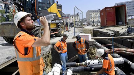 Un salarié du BTP boit de l'eau en plein soleil. Photo d'illustration. (MARC OLLIVIER / MAXPPP)