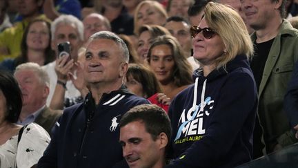 Srdjan et Dijana Djokovic, les parents de Novak, écoutent le discours d'après-match de leur fils, après sa victoire sur le Russe Andrey Rublev à l'Open d'Australie, à Melbourne, le 25 janvier 2023. (DITA ALANGKARA / AP)