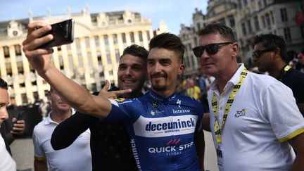 Julian Alaphilippe (C) et son cousin et entraîneur Franck Alaphilippe (D), le 4 juillet 2019. (MARCO BERTORELLO / AFP)