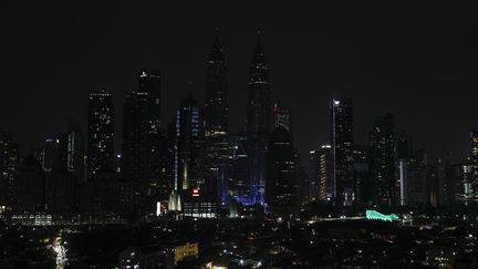 Les tours jumelles Petronas de Kuala Lumpur en Malaisie ont été plongée dans le noir pendant une heure le 26 mars 2022, à l'occasion de l'opération Earth Hour.&nbsp; (FAZRY ISMAIL / EPA)