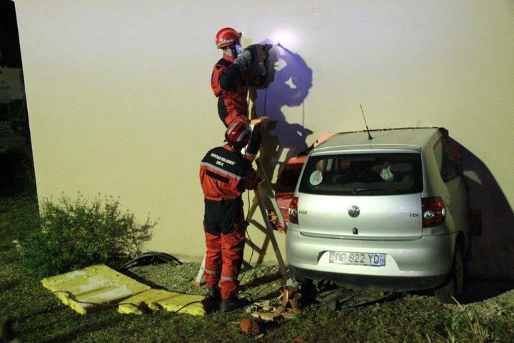 Des pompiers s'activent &agrave; Carlux (Dordogne) pour extraire le v&eacute;hicule de la maison dans laquelle il s'&eacute;tait encastr&eacute;, le 17 octobre 2015. (SDIS24)