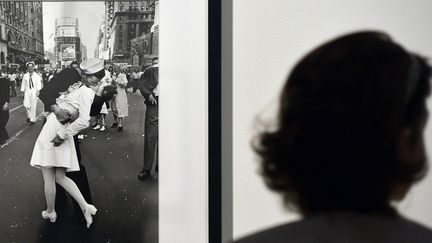 Une femme regarde la photo "V-J Day in Times Square" d'Alfred Eisenstaedt, expos&eacute;e&nbsp;&agrave; Rome (Italie), le 1er ao&ucirc;t 2013. (GABRIEL BOUYS / AFP)