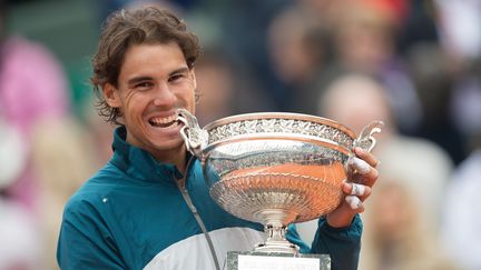 L'Espagnol Rafael Nadal croque dans le troph&eacute;e apr&egrave;s sa victoire &agrave; Roland-Garros, le 9 juin 2013. (JPDN / SIPA)