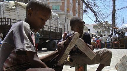 Des jeunes orphelins cirent des chaussures dans les rues de  Mogadiscio pour survivre.
	 
	En Somalie, le taux de scolarisation est très faible, les enfants commencent à travailler très jeunes. (AFP PHOTO/Mustafa ABDI)