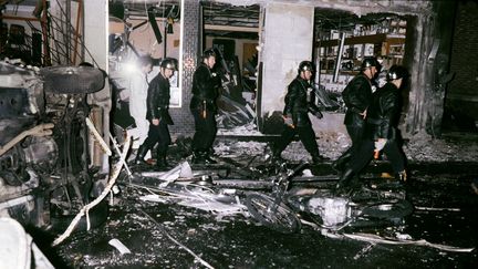 Des secouristes traversent les décombres après l'explosion, le 3 octobre 1980 à Paris. (GEORGES GOBET / AFP)