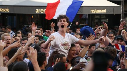 Des supporters fêtent la victoire des Bleus face à l'Uruguay (2 à 0) en Coupe du monde, à Paris, le 6 juillet. (ZAKARIA ABDELKAFI / AFP)