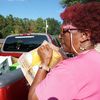 Une bénévole charge des bouteilles de jus dans une voiture, lors d'une distribution alimentaire à Hayneville (Alabama, Etats-Unis), le 17 septembre 2024. (MARIE-VIOLETTE BERNARD / FRANCEINFO)