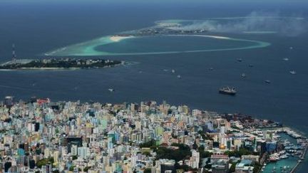 Maldives, septembre 2013. Au marge de l'île capitale de Malé, de la fumée s'échappe de l'île poubelle de Thilafushi. (ROBERTO SCHMIDT / AFP)