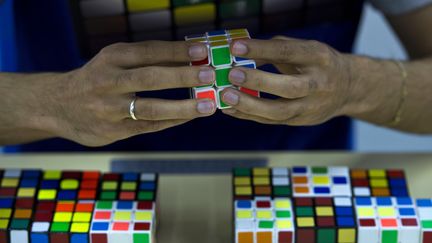 Un participant aux chmapionnats du monde de Rubik's cube compl&egrave;te son casse-t&ecirc;te, le 17 juillet &agrave; Sao Paulo (Br&eacute;sil). (NELSON ALMEIDA / AFP)