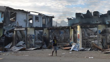 Un homme examine les dégâts à Honiara, alors qu'un calme tendu est revenu après des jours d'émeutes intenses,&nbsp; le 27 novembre 2021. (CHARLEY PIRINGI / AFP)