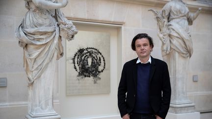 L'artiste&nbsp;Jean-Michel Othoniel posait en mai 2019 devant une des six peintures de son installation "La Rose du Louvre". Son oeuvre va rejoindre la collection permanente du musée.&nbsp; (THOMAS SAMSON / AFP)