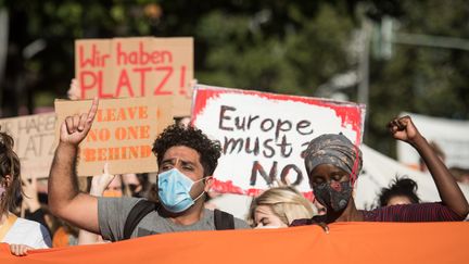 Des manifestants à Berlin (Allemagne) réclament l'accueil des demandeurs d'asile du camp grec de la Moria par les pays membres de l'Union européenne, le 20 septembre 2020.&nbsp; (STEFANIE LOOS / AFP)