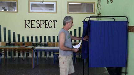 &nbsp; (Un électeur dans un bureau de vote d'Athènes © SIPA/AP - Thanassis Stavrakis)