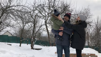 David Culot, son épouse Anna&nbsp;et leur enfant Raphaël dans leur jardin à Kharkiv (Ukraine), le 2 février 2022. (RAPHAEL GODET / FRANCEINFO)
