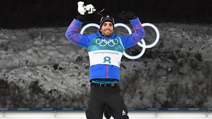 Martin Fourcade saute du podium après sa victoire en poursuite aux JO d'hiver de Pyeongchang (Corée du Sud), le 12 février 2018. (FRANCK FIFE / AFP)