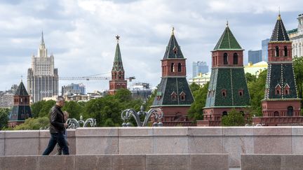 Des personnes traversent un pont avec les tours du Kremlin en arrière-plan dans le centre de Moscou, le 17 mai 2020. Photo d'illustration. (YURI KADOBNOV / AFP)