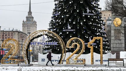 Un homme marche à côté d'une décoration de Noël dans le centre de Moscou (Russie), le 24 décembre 2020. (ALEXANDER NEMENOV / AFP)