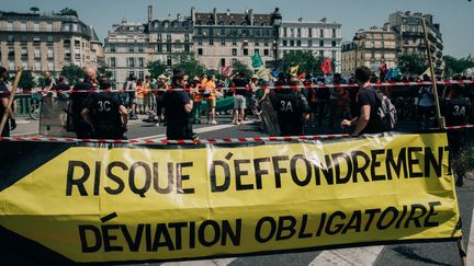 Des militants du collectif&nbsp;Extinction Rébellion tentent de bloquer le pont de Sully, à Paris, le 28 juin 2019.&nbsp; (MATHIAS ZWICK / HANS LUCAS / AFP)