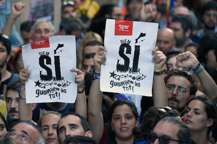 Des manifestants pro-indépendance brandissent des affichettes en faveur du "oui", à Barcelone (Espagne), le 20 septembre 2017, lors d'une manifestation. (LLUIS GENE / AFP)