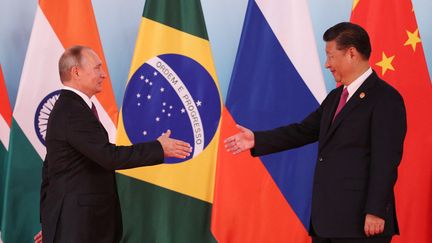 Le président chinois Xi Jinping (à droite), serre la main du président russe Vladimir Poutine, lors du sommet des BRICS (Brésil, Russie, Inde, Chine et Afrique du Sud) en septembre 2017. (WU HONG / POOL)