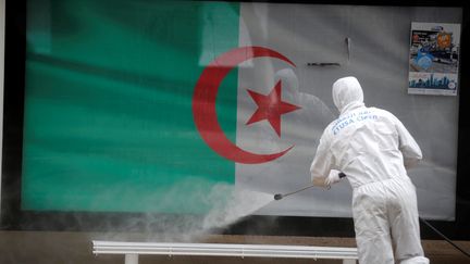 Un agent de santé désinfecte un abribus dans les rues d'Alger. L'Algérie est le pays africain qui compte à ce jour le plus grand nombre de décès liés au Covid-19. Photo prise le 20 mars 2020.&nbsp; (Billal Bensalem / NurPhoto / NurPhoto via AFP)