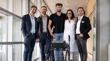 Gert-Jan entouré de l'équipe médicale suisse qui a développé la technologie lui permettant de remarcher. À sa droite, la neurochirurgienne Jocelyne Bloch et le neuroscientifique Grégoire Courtine. (FABRICE COFFRINI / AFP)