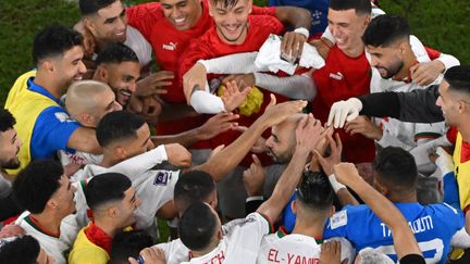 Les joueurs marocains célèbrent leur qualification pour les huitièmes de finale de la Coupe du monde Qatar 2022 à Doha, le 1er décembre 2022 (ANTONIN THUILLIER / AFP)