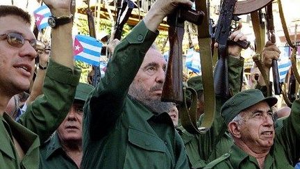 2001. Castro et ses proches brandissent des Kalachnikov pour célébrer le 40e anniversaire d'une date clef de la révolution cubaine. En 1961, l'opération menée par les Américains dans la baie des Cochons avait lamentablement échoué, confortant le régime castriste issu de la révolution de 1959. (ADALBERTO ROQUE / AFP)