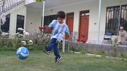 Murtaza, un petit Afghan de 5 ans, joue avec son maillot dédicacé par Lionel Messi, le 3 mai 2016, à Quetta&nbsp;(Pakistan). (MAZHAR CHANDIO / AFP)