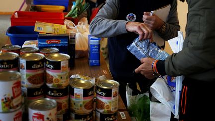 Un bénévole des Restos du Coeur distribue de la nourriture à Saint-Lo, dans le département de la Manche, le 29 novembre 2018. (CHARLY TRIBALLEAU / AFP)