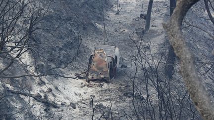 La carcasse d'un véhicule brûlé dans l'incendie de Carros (Alpes-Maritimes), lundi 24 juillet 2017.&nbsp; (VALERY HACHE / AFP)