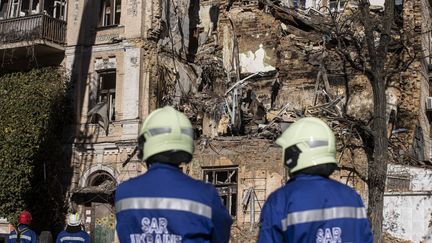 Les services de secours ukrainiens inspectent un bâtiment détruit par une frappe de drones kamikazes, le 18 octobre 2022, à Kiev (Ukraine).&nbsp; (METIN AKTAS / ANADOLU AGENCY / AFP)