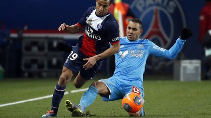 Le Marseillais Dimitri Payet (&agrave; droite) tacle le Parisien Lucas Moura, le 2 mars 2014 au Parc des Princes. (THOMAS SAMSON / AFP)