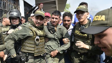 Des policiers colombiens accompagnent un officier vénézuelien, le 23 février 2019, à&nbsp;la frontière entre le Venezuela et la Colombie, à&nbsp;Cucuta. (LUIS ROBAYO / AFP)