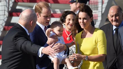 Le prince Georges, entour&eacute; de sa m&egrave;re Kate Middleton et de son p&egrave;re le prince William, lors de leur arriv&eacute;e &agrave; l'a&eacute;roport de Sydney pour une visite officielle en Australie et en Nouvelle-Z&eacute;lande, le 16 avril 2014.&nbsp; (WILLIAM WEST / AFP)