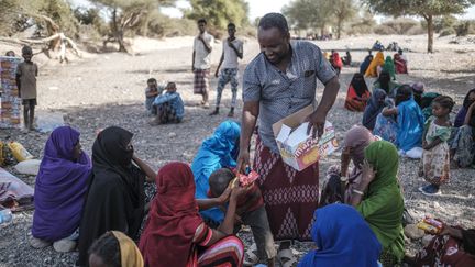 Un homme distribue de la nourriture dans un camp de personnes déplacées dans la région de Semera (Ethiopie) le 15 février 2022 (EDUARDO SOTERAS / AFP)