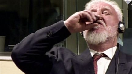 Capture d'écran d'une vidéo montrant Slobodan&nbsp;Praljak ingérant du cyanure de potassium, le 29 novembre 2017, au Tribunal pénal international pour l'ex-Yougoslavie, à La Haye (Pays-Bas). (INTERNATIONAL CRIMINAL TRIBUNAL / AFP)