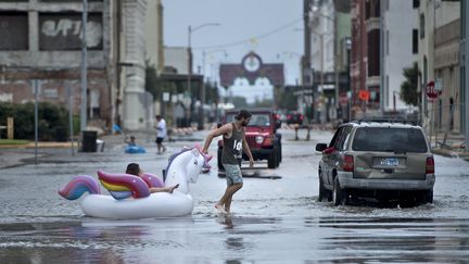 Dans les villes inondées, comme ici à Galveston, les habitants se déplacent parfois grâce à de simples bouées de piscine. (BRENDAN SMIALOWSKI / AFP)