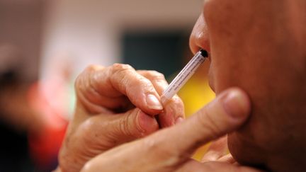 Un patient se fait vacciner contre le virus H1N1 par spray nasal aux Etats-Unis. Photo d'illustration. (TIM SLOAN / AFP)