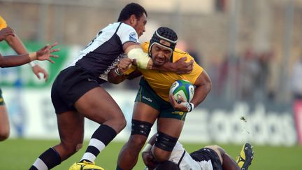 Le jeune rugbyman fidjien&nbsp;Laijaisa&nbsp;Bolenaivalu (&agrave; gauche, maillot bleu) lors d'un match de la Coupe du monde junior &agrave; Vannes (France), le 13 juin 2013. (DAMIEN MEYER / AFP)