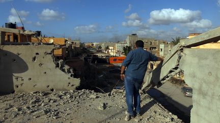 Un homme sur un toit de Benghazi après la reprise de la ville par les forces du gouvernement reconnu par la communauté internationale, le 25 février 2016. (ABDULLAH DOMA / AFP)